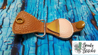 Guitar pic key fob in the hoop embroidery file by spunky stitches.